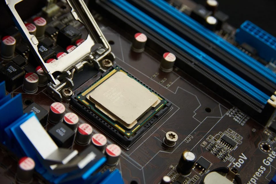 Placa-mãe de computador em close, com o processador e os encaixes de memória